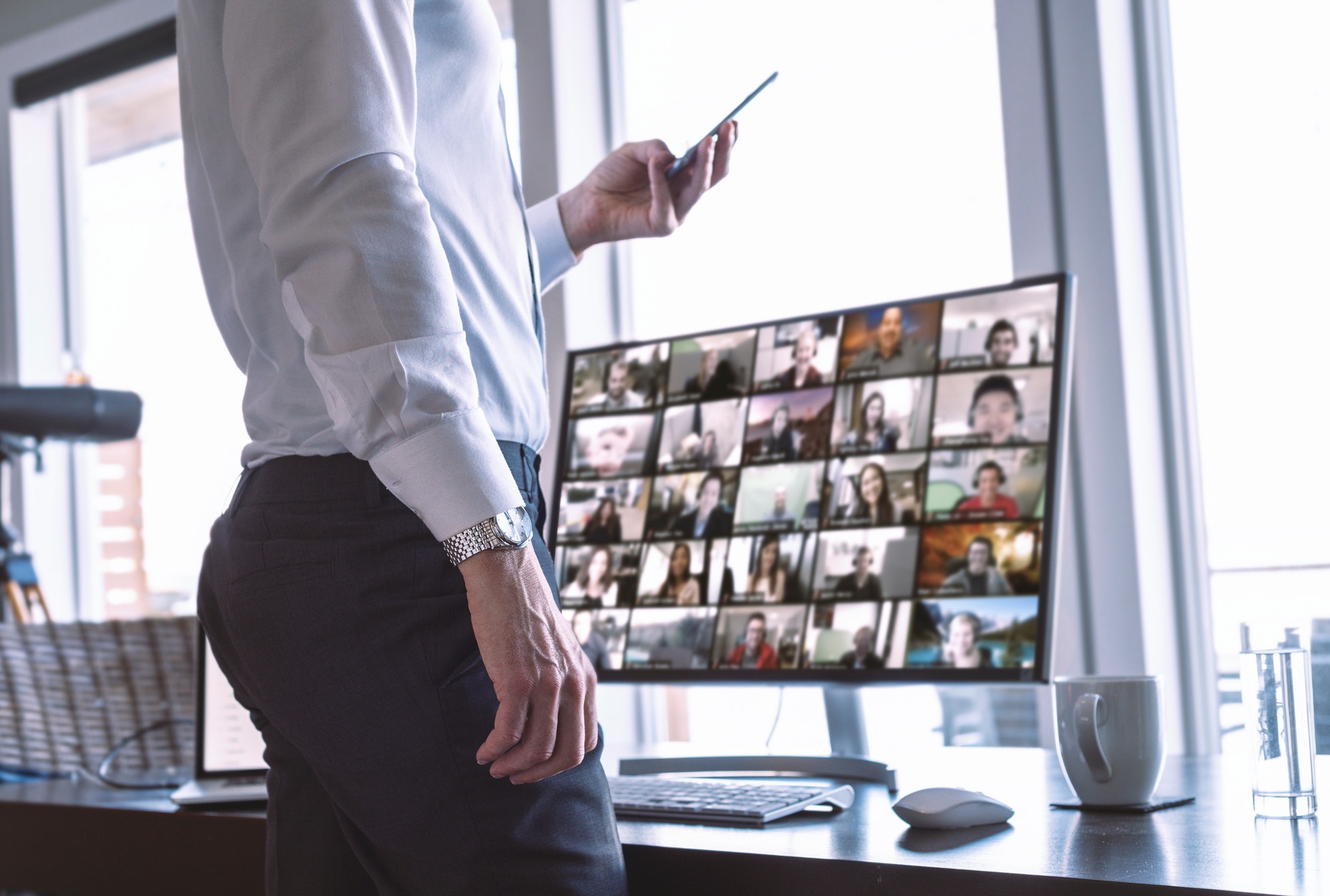Businessman with his team on video chat computer screen, using phone Businessman with his team on video chat computer screen, using phone