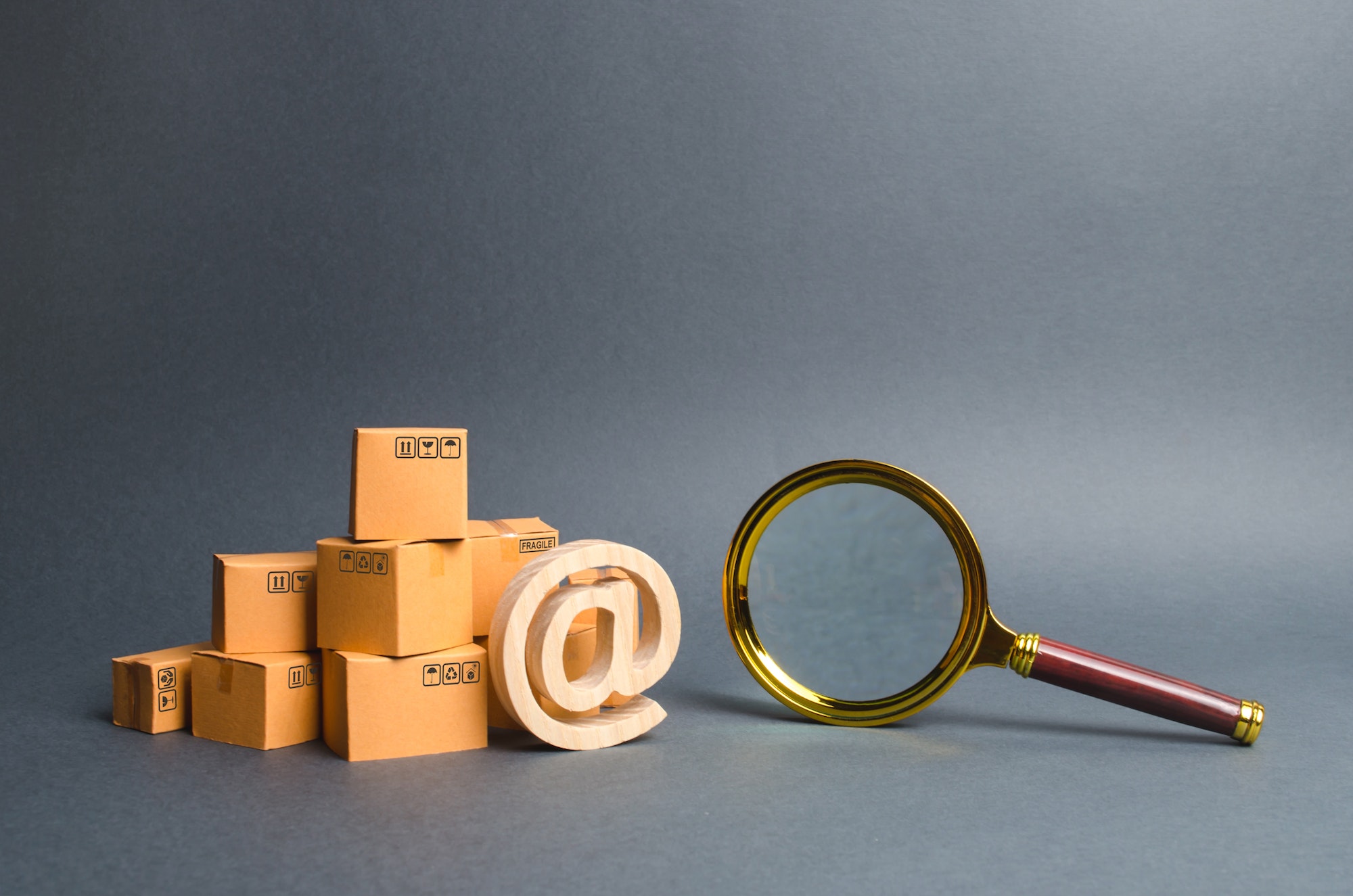 Pile of boxes with email symbol AT and a magnifying glass